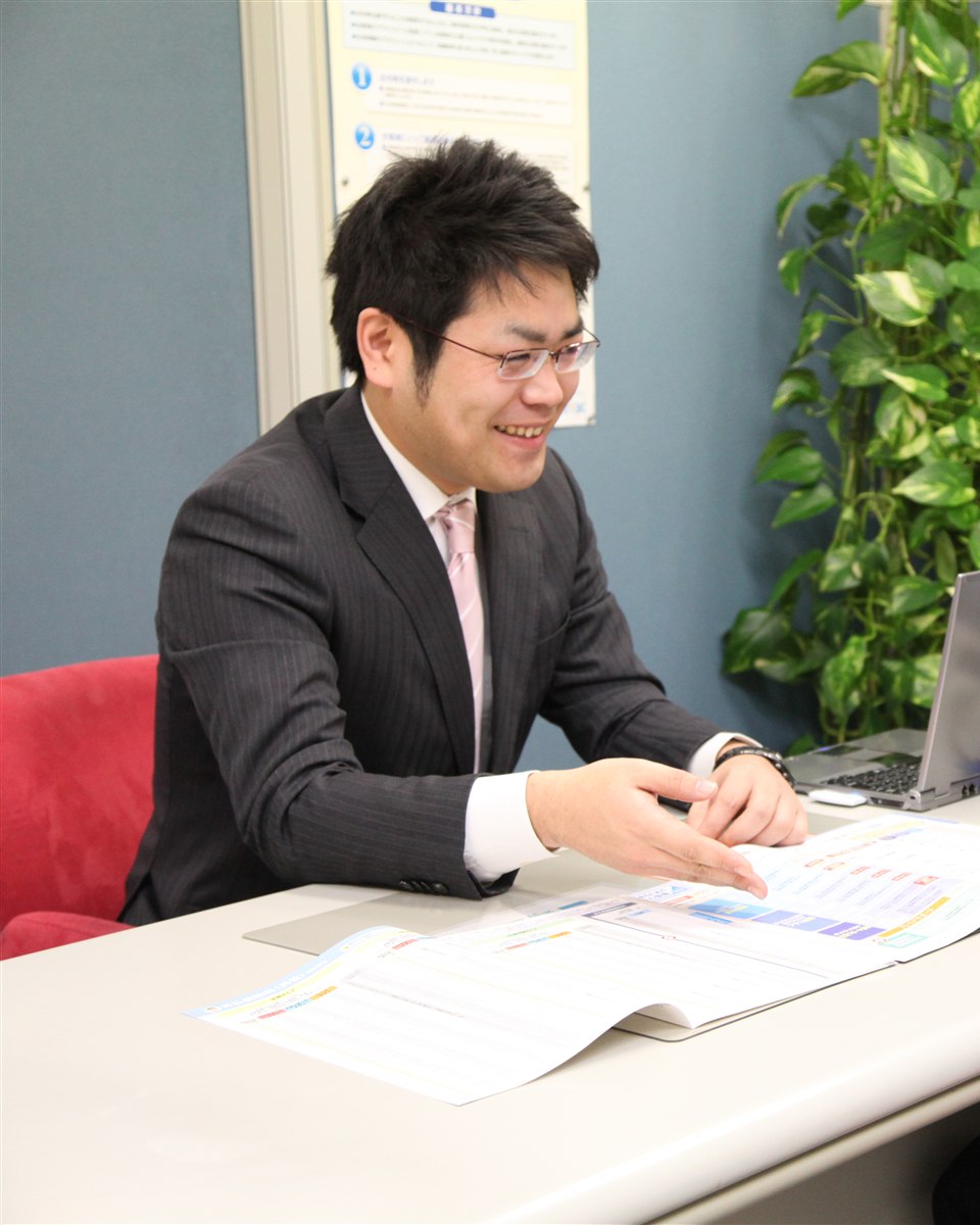 資料を示しながら保険について説明する担当者